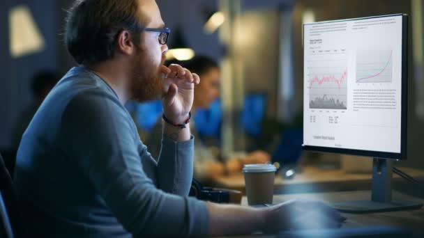 Professional Statistician Works with Graphics on His Personal Computer. In the Background His Colleagues Working. — Stock Video