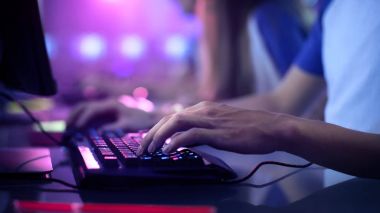 Yakın çekim üzerinde oyun'ın bir klavyede, aktif olarak iterek düğmeleri, oyun Mmo Oyunlar Online eller. Arka plan ile Neon ışıkları yanıyor.