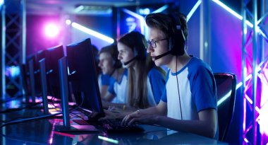 Team of Teenage Gamers Play in Multiplayer PC Video Game on a eSport Tournament. Captain Gives Commands into Microphone, Trying Strategically Win the Game. clipart