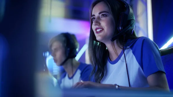 Красива професійна дівчина-геймер і її команда беруть участь у кіберспортивному турнірі. Вона має навушники і як керівник команди вона командує стратегічними маневрами в мікрофон . — стокове фото