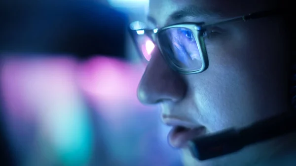 Close-up van tiener bril spelen van videogames in zijn hoofdtelefoon geven opdrachten in microfoon. — Stockfoto