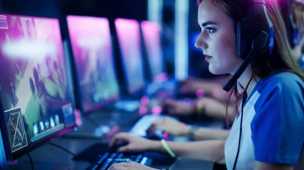 Professionelle Mädchen spielen in mmorpg / Strategie-Videospiel auf ihrem Computer. Sie nimmt an Online-Cyber-Games-Turnieren teil, spielt zu Hause oder im Internet-Café. Sie trägt Gaming-Kopfhörer. — Stockfoto