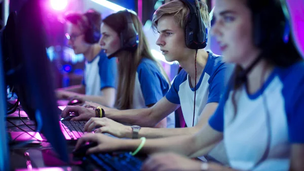 Team of Professional eSport Gamers Jogando em Jogos de Vídeo Competitivos em um Torneio de Jogos Cibernéticos. Eles usam microfones . — Fotografia de Stock