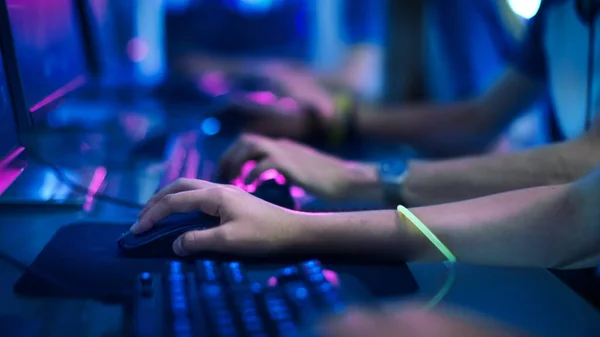 Primer plano en la fila de manos del jugador en un teclado, pulsando activamente botones, jugando juegos MMO en línea. Fondo es Lit con luces de neón . — Foto de Stock