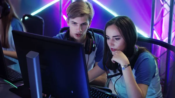 Boy and Girl Gamers Pensando activamente / Discutiendo la estrategia / táctica del juego, están en Internet Café o en el Torneo de Cyber Juegos . —  Fotos de Stock