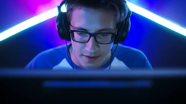 Професійний гравець грає в Mmorpg / стратегії / шутер на своєму комп'ютері. Він бере участь в онлайн кібер Ігри турніру, грає вдома або в Інтернет-кафе. Він носить окуляри та ігрові навушники, говорить у мікрофон. Стокова Картинка
