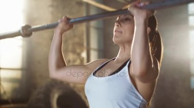 Güçlü atletik kadın mı asansörleri halter Bar onun Merkez Over. O bir spor salonunda Fitness eğitim çalışmaları çapraz.