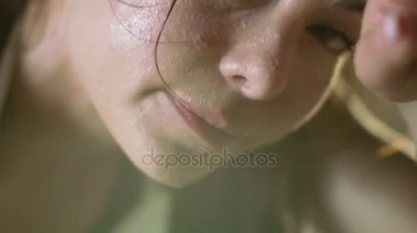 Yakın çekim Shot güzel bir atletik kadının alnının elle görünüyor içine kamera Teri siliyor. Fitness Egzersiz yoğun geçtikten sonra çok yoruldu.