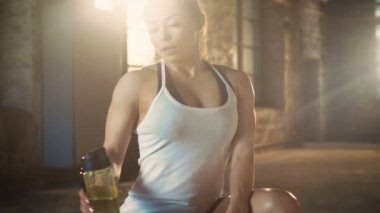 Onun en sevdiği spor salonunda Fitness vücut geliştirme eğitim çapraz yorucu sonra bir su şişesi güçlü atletik kadın içecekler.