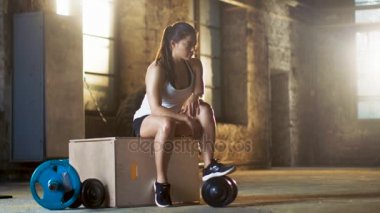 Onun yoğun izlemek için güzel atletik kadın kullanır Smartphone onun favori spor salonunda Fitness vücut geliştirme egzersiz programı çapraz.