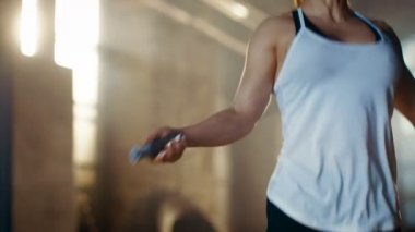 Atletik güzel kadın çalışmaları ile atlama / bir spor salonunda ip atlama. Onun yoğun Fitness eğitimin bir parçası yapıyor.