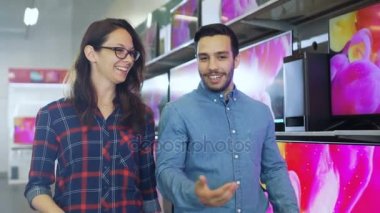 İki genç yürüyor ve seçme ve karar yeni bir Tv Talking elektronik mağazasında ayarla.