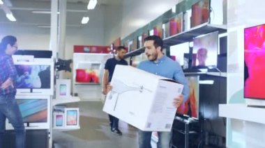 Elektronik mağazasından genç adam büyük uçak ve dans etmek mutlu ile belgili tanımlık kutu satın aldı. Parlak ve Modern deposu vardır deposundaki tüm son cihazlar.