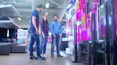 Elektronik mağaza profesyonel danışman yaklaşımlar genç çift, yeni modelleri 4 k onun uzman tavsiyeler ile TV en iyisi onların ana sayfa ve bütçe için.