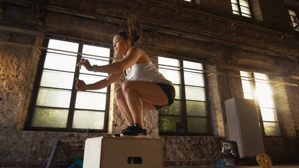 Fit Athletic Woman Does Box Jumps in the Deserted Factory Gym. I — Stock Photo, Image