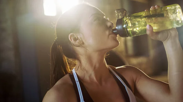 Forte femme sportive boit à partir d'une bouteille d'eau après l'épuisement — Photo