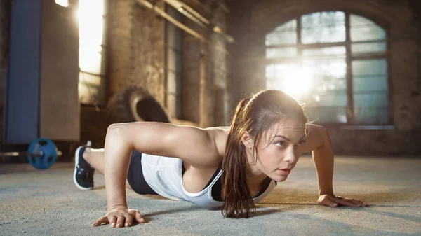 Atlética hermosa mujer does push-ups como parte de su cruz Fitn —  Fotos de Stock