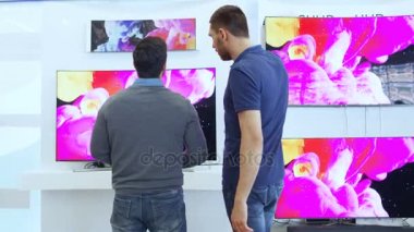 Onlar Discus özellikleri ve ne Model bir genç adam için elektronik mağaza profesyonel danışman gösterir son 4 k Uhd TV içinde olduğunu en iyi genç adamın evi için. Mağaza parlak, Modern ve en son modelleri.