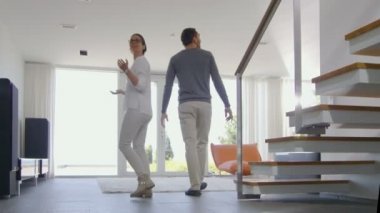 Güzel genç çift yeni satın evlerine giren çok mutlular. Parlak, Modern ve tavan pencere zemin vardır kendi evim.