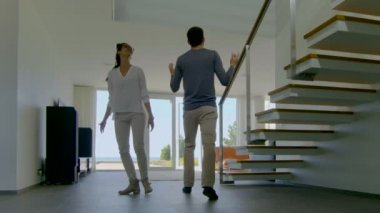 Güzel genç çift yeni satın evlerine giren çok mutlular. Parlak, Modern ve kat tavana uzanan pencereler ve sahil görünümü vardır onların lüks evim.