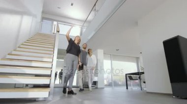 Profesyonel emlakçı şık Modern ev için güzel bir genç çift gösterir.. 