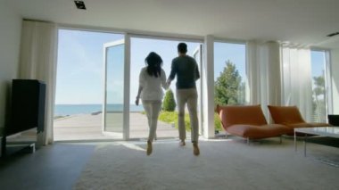 Mutlu genç çift tutan eller ishal dışarı onların eve Deniz Manzaralı Teras üzerine. 