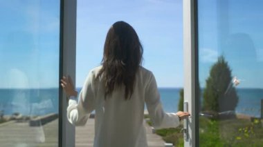 Ateş bağsız kıl Güneşli terasta Deniz Manzaralı yürüyüş ile güzel bir esmer takip. Bulutsuz sabah oldu ve o gerçekten mutlu mu.