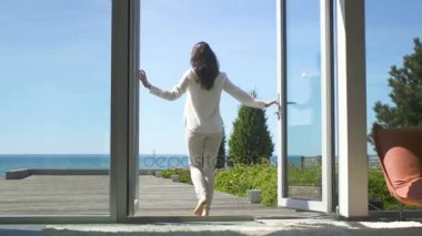 Güzel bir esmer atış bağsız kıl Açılış kapılar balkon ve Deniz Manzaralı güneşli Teras üzerine yürüme ile takip. Bulutsuz sabah oldu ve o gerçekten mutlu mu.