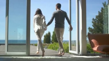  Güzel çift Walsk onların ev bir sahil görünümü, onlar mutlu kucaklamak ve birlikte Spin güneşli Teras üzerine dışarı. Gökyüzü Cloudless ve mutlu insanlar.