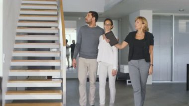 Profesyonel emlakçı gösterir şık Modern ev satın alma / yeni ev kiralamak için piyasada olan güzel genç bir çift için. Modern, şık ve parlak evim.