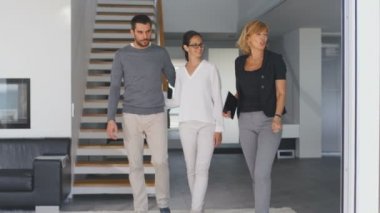 Profesyonel emlakçı gösterir şık Modern ev satın alma / yeni ev kiralamak için piyasada olan güzel genç bir çift için. Modern, şık ve parlak evim.