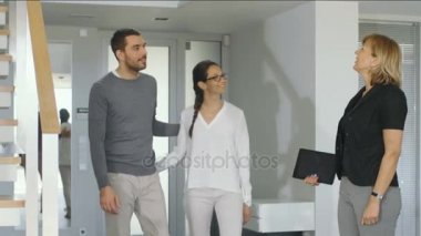 Profesyonel emlakçı gösterir şık Modern ev satın alma / yeni ev kiralamak için piyasada olan güzel genç bir çift için. Modern, şık ve parlak evim.
