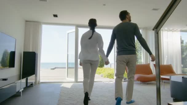 Jovem casal feliz segurando as mãos e muito apaixonado Corra para fora de sua casa para o terraço com vista para o mar . — Vídeo de Stock