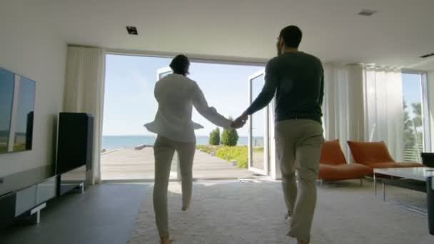 Happy Young Couple Holding Hands  Runs out of Their Home onto the Terrace with the Seaside View. — Stock Video