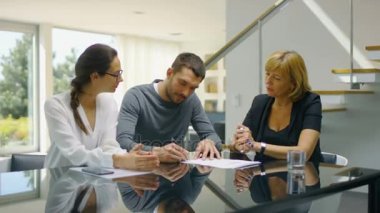 Masada oturan yaşam işaretleri sözleşme güzel genç çift ve satın House, emlakçı evin anahtarları verir. Sunny ve parlak evim. Çift mutlu, herkes gülümsüyor olduğunu.