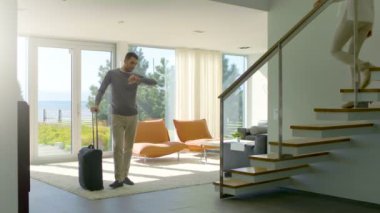 Koca bir çanta ile eşi için bekler ve o aşağı gelir ve mutlu tatil için bırakır. Sunny evim.