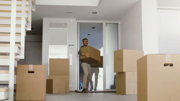 Cajas de movimiento de pareja feliz con cosas en su nueva casa brillante y moderna. Un montón de cajas ya están en la habitación . — Vídeos de Stock