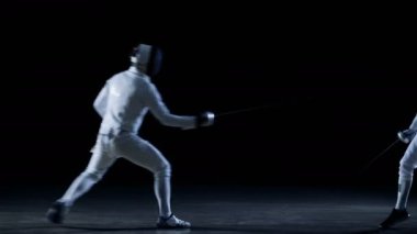 İki profesyonel eskrimcilerin göstermek ustaca kılıç onların folyo Fight. Bir güzel Fleche saldırı yapar. Siyah arka plan üzerine izole atış .