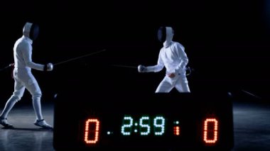 Şampiyonluk iki profesyonel tam donanımlı eskrimcilerin ustalıkla mücadele ile üzerinde sayısı puanları çetele tutar Foils. Onlar saldırı, savunma, sıçrama, itme ve saldır. İzole siyah arka plan üzerine ateş. 