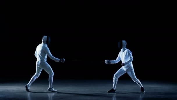 Dva profesionální šermíři, plně vybavené odborně bojovat s fólií. Záběr na černém pozadí s modrými podtóny, samostatný. — Stock video