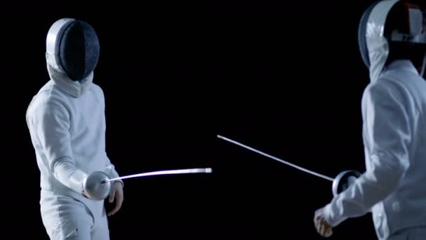 2 전문 Fencers 표시 대작 검 술 그들의 포 일 싸움에. 그들은 공격, 방어, 도약 및 추력과 돌출. 총 검은 배경에 및 슬로우 모션에서 절연. — 비디오