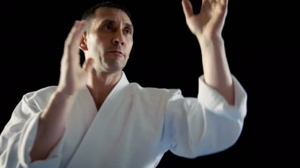 Close-up Shot of the Martial Arts Master Reflecting Fist Blows From His Sparring Partner and Overpowering Him. Shot Isolated on the Black Background. — Stock Video