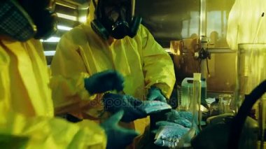Yeraltı laboratuvarda koruyucu maskeler ve tulum giyen iki gizli kimyagerler paketi çanta sentezlenen Crystal meth kutuları daha fazla dağıtım için. Laboratuvar tam, yasadışı cihazıdır. Onlar terk edilmiş bir binada ağız kavgası.