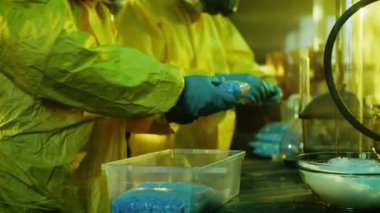 Yeraltı laboratuvarda iki gizli kimyagerler kutulara ilaçların çanta paketi. Laboratuvar tam, yasadışı cihazıdır. Onlar terk edilmiş bir binada ağız kavgası.