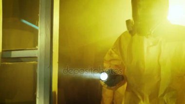 İki subay tehlikeli madde polis birimi bozuk uyuşturucu laboratuvarı yapma inceleyin. Onlar giyim Hazmat uygun ve gaz maskeleri ve dikkatle el feneri ile yürüyüş.