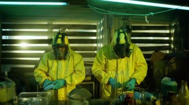 Yeraltı laboratuvarda iki gizli kimyagerler kutulara ilaçların çanta paketi. Tam cam ve diğer uyuşturucu üretim ilgili ekipmanlar laboratuvardır. Onlar terk edilmiş bir binada ağız kavgası.