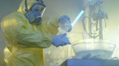 Yeraltı laboratuvarda koruyucu tulum içinde gizli kimyagerler paketi mavi kristal Meth yeni pişmiş toplu çanta içinde daha fazla sokak dağıtım için. Onlar yasadışı uyuşturucu terk edilmiş binada Re-eşke özel laboratuar ekipmanları ile pişirmek