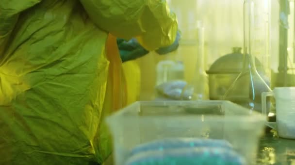 Im Untergrundlabor verpacken geheime Chemiker in Schutzanzügen frisch gekochte Chargen Drogen. Sie kochen illegal Drogen mit speziellen Laborgeräten in dem verlassenen Labor. — Stockvideo