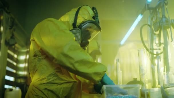W podziemnym laboratorium chemików w pakiecie odzieży ochronnej dla dystrybucji nowo gotowane partii narkotyków. Gotują nielegalnie leków z wyposażeniem specjalnym laboratorium w opuszczonym laboratorium. — Wideo stockowe