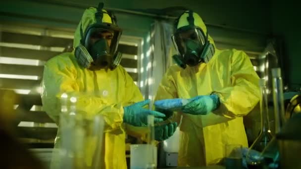 지 하 실험실에서 2 명의 은밀한 화학자 상자에 약물의 가방을 팩. 실험실 유리 그릇 전체 및 기타 마약 생산 관련 장비입니다. 그들은 버려진된 건물에 쪼 그리고 앉아서. — 비디오